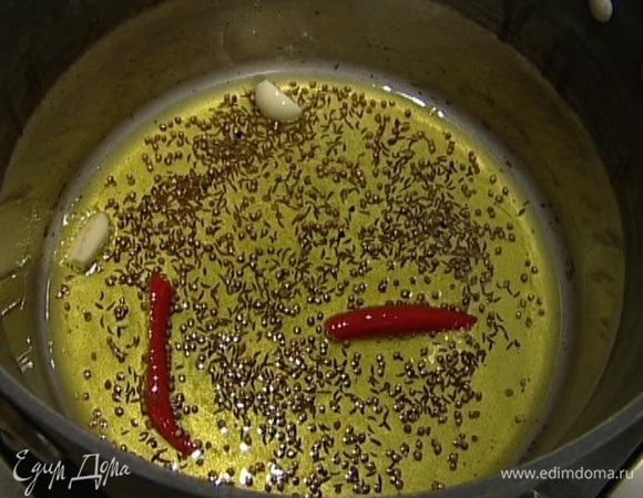 Разогреть в кастрюле оливковое масло, выложить чеснок и чили, всыпать тмин и кориандр, все слегка прогреть.