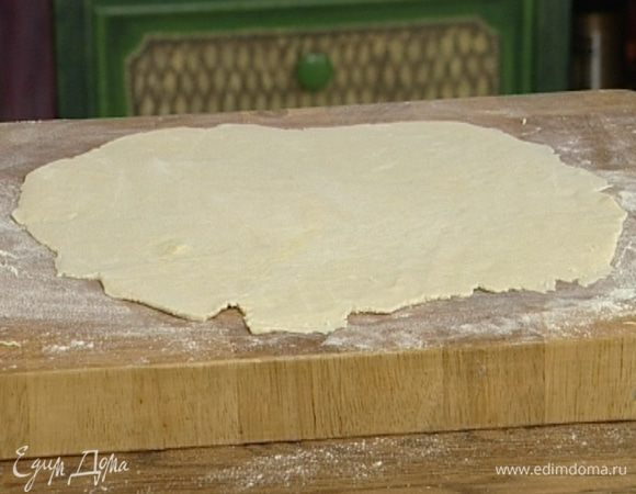 Половину охлажденного теста раскатать в квадрат 30х30 см и разрезать на квадратики 10х10 см. На середину каждого положить немного начинки.