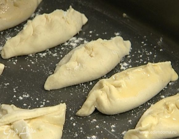 Остатки теста раскатать, нарезать тонкими полосками, уложить их крест-накрест на каждый пирожок и тоже смазать яйцом с молоком. 