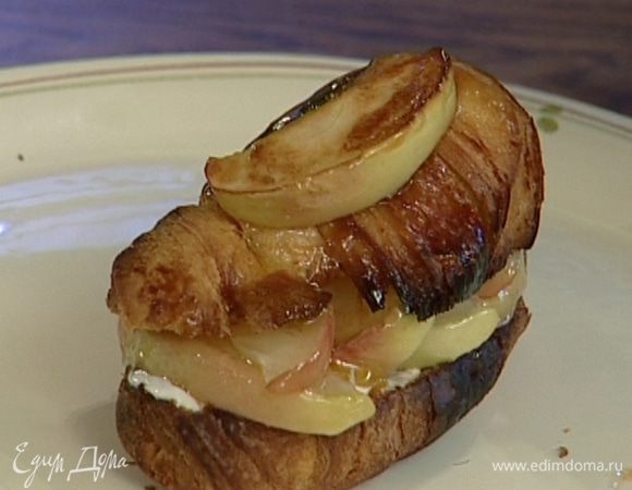 Смазать одну часть круассана сметаной, сверху положить немного яблок, накрыть второй половиной круассана и полить яблочной карамелью.