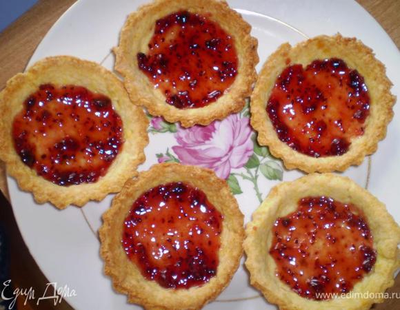 Остывшие песочные корзиночки смазываем вареньем