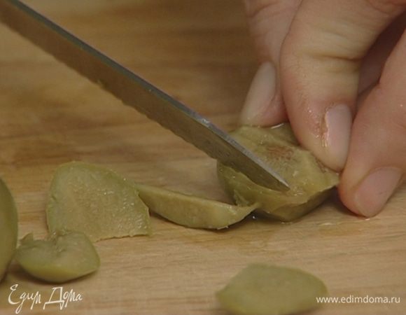 Оливки, удалив косточки, крупно нарезать.