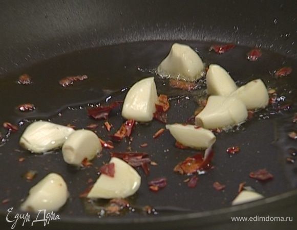 Половинку перца чили раскрошить и отправить к чесноку.