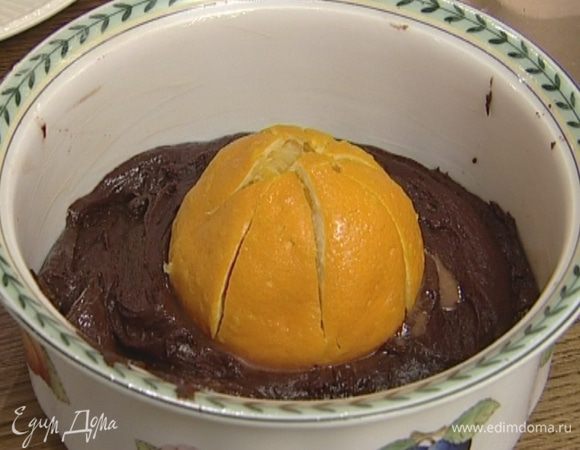 Поместить апельсин в центр формы, вдавив его наполовину в тесто.