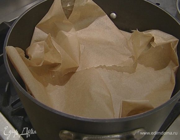 Накрыть кастрюлю бумагой для выпечки и прижать ее крышкой.