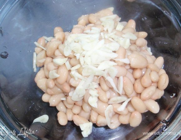 Фасоль в собственном соку промыть от рассола. Это не обязательно, но мне кажется так вкуснее. Нарезать чеснок, добавить к фасоли и немного примять фасоль. Но не сильно, чтобы всё таки оставались кусочки. Чеснок в соединении с фасолью начинает вкусно благоухать. 