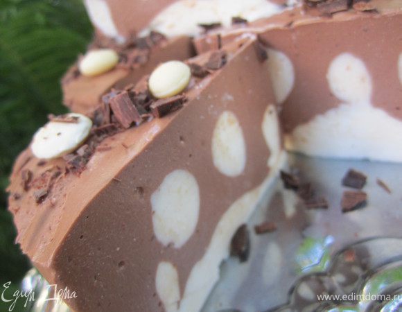 Достать из холодильника.
Освободить от разъемной формы.
Снять пергаментную бумагу.
Выложить на блюдо, порезать позиционно, украсить белым и черным шоколадом.