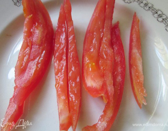 Помидор освободить от сердцевины и нарезать сначала на полоски, а потом на кубики.