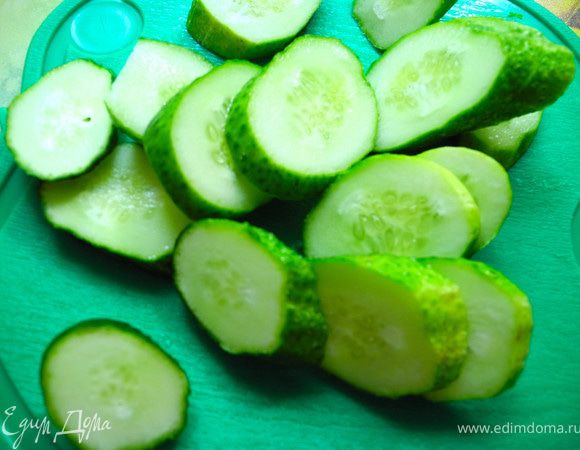 Добавить камбалу, обжарить в течение нескольких минут с одной и другой стороны, затем немного потушить на маленьком огне (минут 5). В это время займемся огурцами. Нарезать их кружочками.