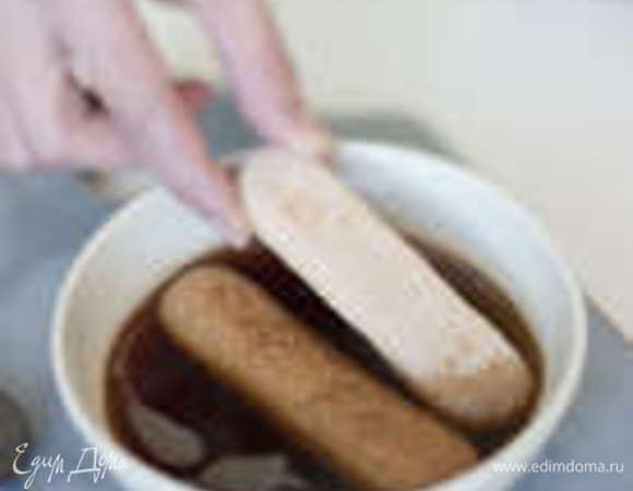 В заваренный кофе добавить коньяк и пропитать кусочки бисквита.