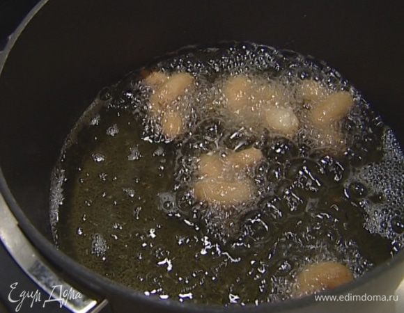 Опускать узелки на 1 минуту в горячее масло, чтобы они стали золотисто-коричневого цвета, а затем выкладывать на бумажное полотенце. 