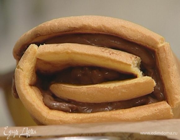 Бисквит развернуть и смазать шоколадным кремом, затем опять свернуть в рулет и присыпать оставшейся сахарной пудрой.