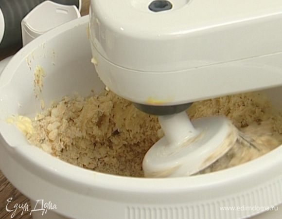 Взбить желтки со 150 г сахара, добавить 200 г предварительно размягченного сливочного масла, затем, продолжая взбивать, ввести орехи, печенье и апельсин.