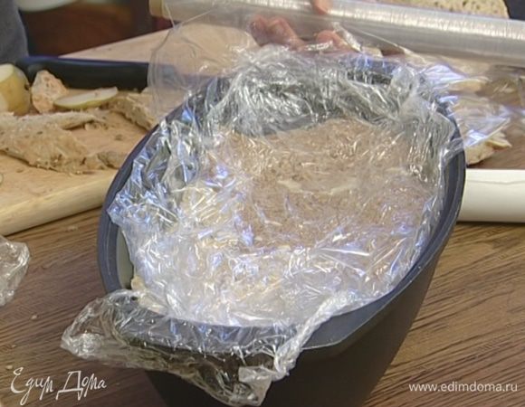 Завернуть края пленки, накрыть бумагой для выпечки, положить сверху гнет и отправить на 3–4 часа в холодильник.