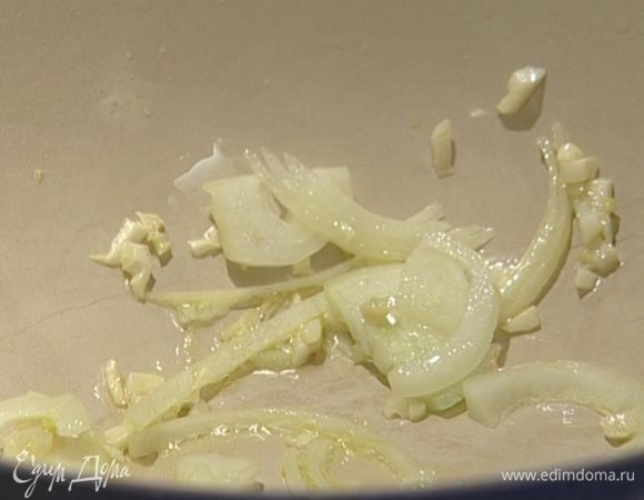 В тяжелой кастрюле с толстым дном разогреть оливковое масло и обжарить репчатый лук и чеснок.