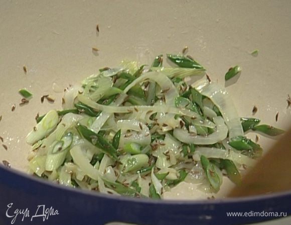 Добавить зеленый лук и тмин, потомить 1–2 минуты.