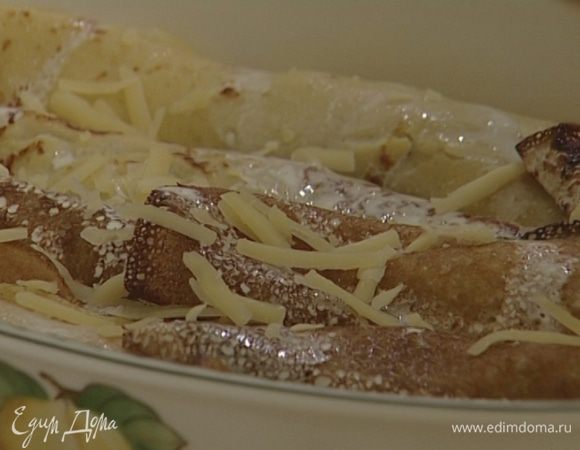 Твердый сыр натереть на мелкой терке, присыпать блины, полить оставшимися сливками и запекать в разогретой духовке 10 минут.