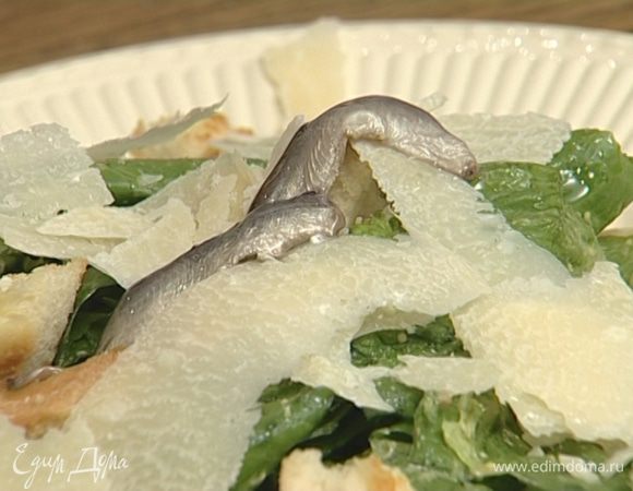 Выложить салат на тарелки, добавить в каждую немного крутонов, пару анчоусов, посыпать все пармезаном.