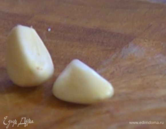 Чеснок почистить и разрезать на четыре части.