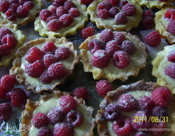 Остывшие корзиночки наполнить кремом (примерно 1-2 ч.л.). Сверху уложить ягоды малины. Присыпать сахарной пудрой.