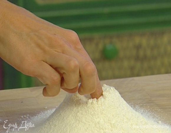 Просеять муку, сделать в ней углубление.