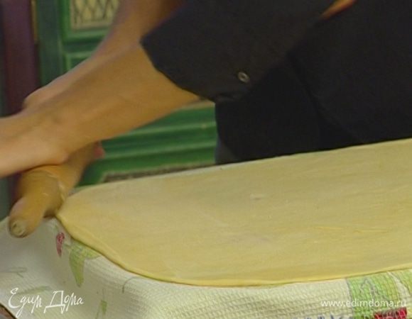 Большое хлопчатобумажное полотенце присыпать мукой, раскатать на нем тесто как можно тоньше.