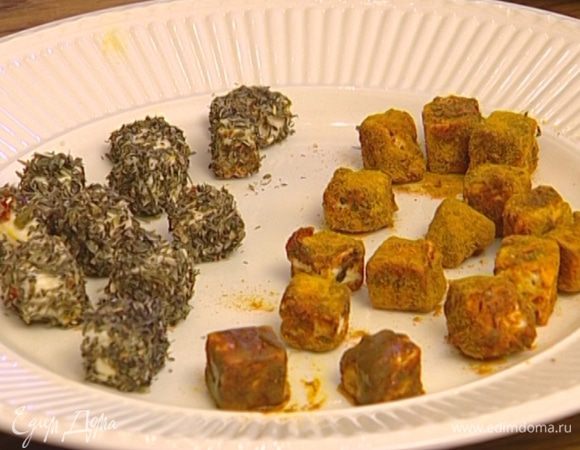 Половину кубиков феты обвалять в куркуме и перце, а вторую половину — в прованских травах.