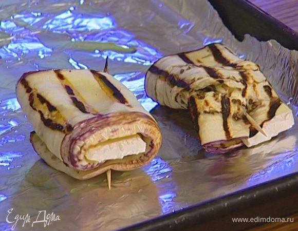 На баклажаны положить понемногу сыра, присыпать измельченными орехами, свернуть в рулетики и скрепить зубочистками. 