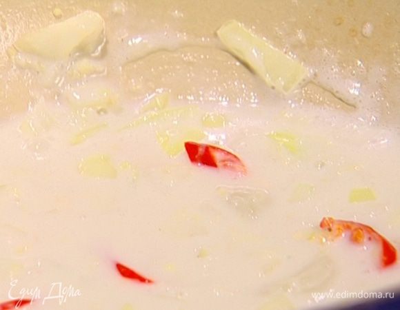 Добавить в подогретое молоко чеснок, половину нарезанного чили, имбирь и лук.