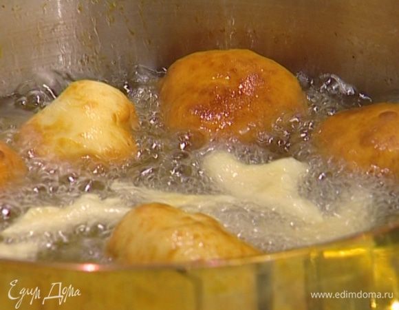 В глубокой сковороде или кастрюле разогреть растительное масло и жарить пончики до золотистого цвета.