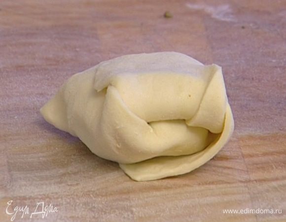 Выложить на тесто кусочек сыра, сверху 1 ч. ложку песто и свернуть тесто в конверт.