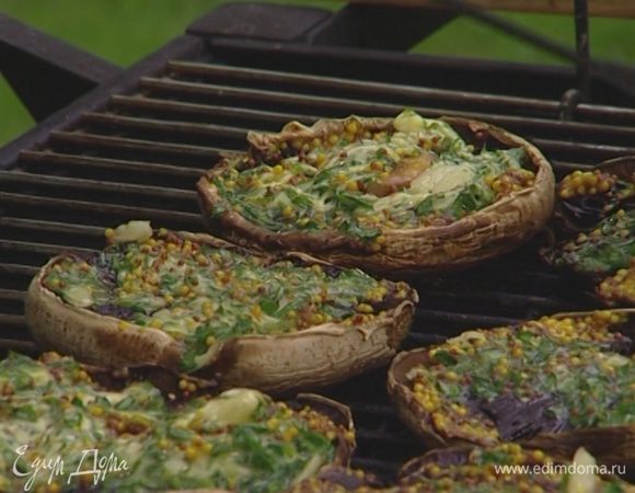 Положить грибы на гриль начинкой вверх и жарить 3–4 минуты.