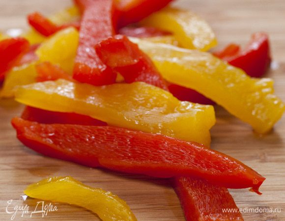 Сладкий перец обжарить на сковороде-гриль или в духовке до готовности, положить на 5 минут в полиэтиленовый пакет. Затем снять кожицу, удалить семена, мякоть нарезать длинными полосками.