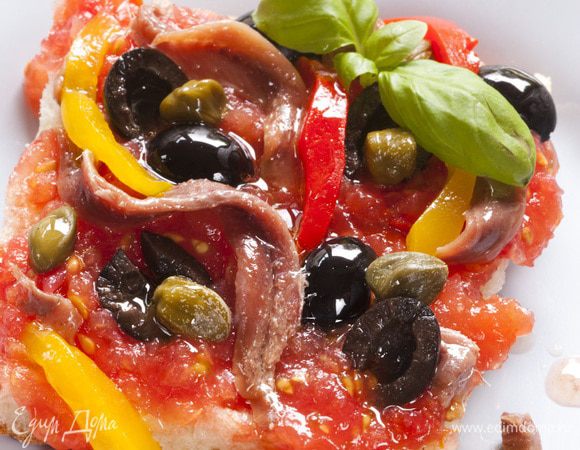 Сверху выложить сладкий перец и присыпать мелко нарезанным анчоусом и листьями базилика.