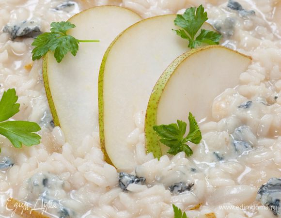 Постепенно, половник за половником, добавлять бульон. Варить ризотто 18–20 минут, постоянно помешивая. В конце добавить оставшиеся груши и кубики сыра, присыпать петрушкой. Осторожно перемешать и подавать тут же.