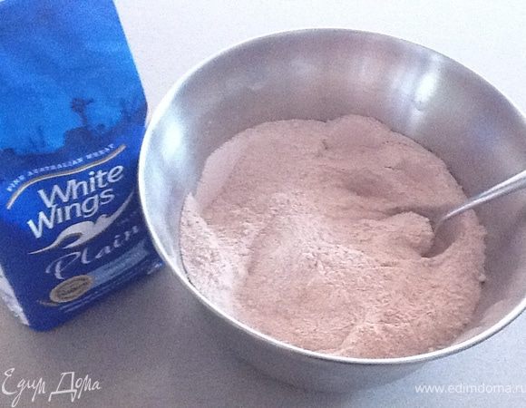 Просеять муку, добавить к ней какао порошок + соду. Все тщательно перемешать. Всыпать мелкий сахар и еще раз все размешать.