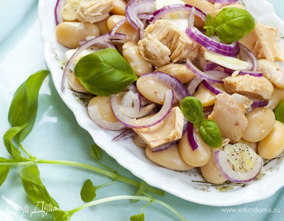 Сверху разложить кусочки тунца, присыпать измельченным руками базиликом (немного листьев оставить), полить оставшейся заправкой с луком и чесноком и украсить оставшимся базиликом. Подавать тут же!