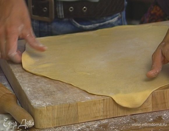 Присыпать рабочую поверхность оставшейся мукой и раскатать тесто как можно тоньше.