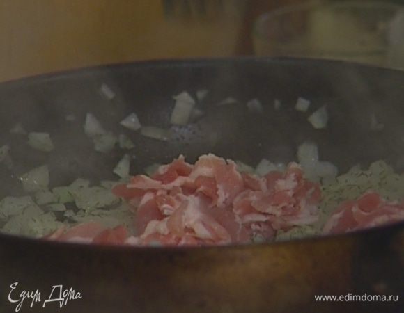 Разогреть в сковороде подсолнечное масло и обжарить лук вместе с беконом.