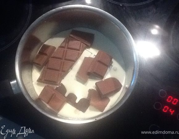Пока торт выпекается, подготовим ГАНАШ: шоколад + сливки вылить в небольшую кострюльку и на маленьком огне помешивая ждем растворения шоколада, дабы смесь стала однородной. Снять с огня.