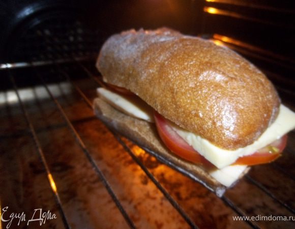 Приготовьте начинку для сэнндвича:нарежьте ломтиками сыр.Помидоры порежьте кружочками.Нарежьте хлеб, и на каждый кусочек положите сыр и помидор.Накройте другим ломтиком хлеба.Поместите сэндвичи на решетку гриля, сбрысгните олив.маслом.