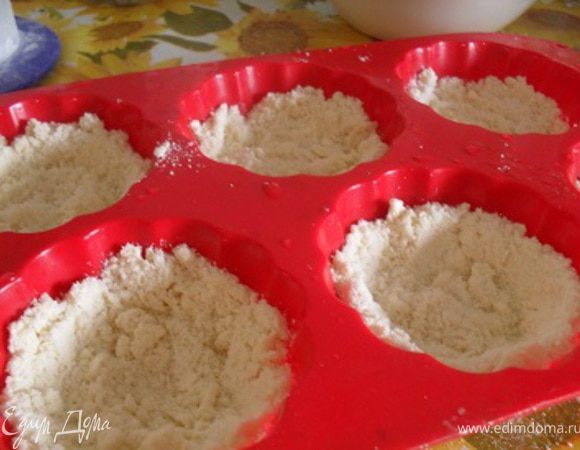 Формочки для маффинов смазать маслом, уложить слой крошки, сделать бортики.