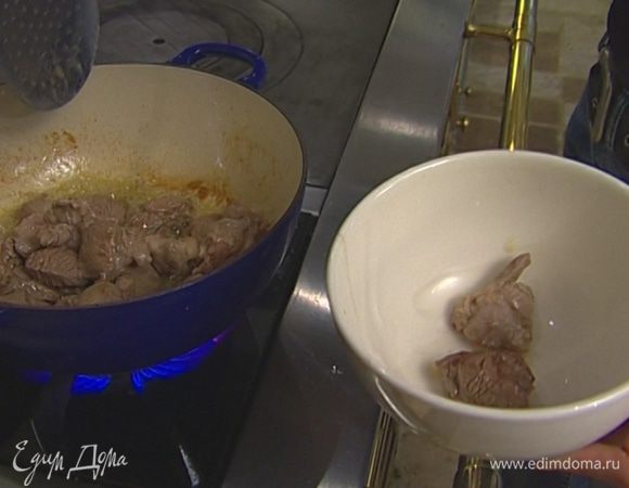В тяжелой кастрюле, которую можно ставить в духовку, разогреть растительное масло и обжаривать баранину на сильном огне до появления золотистой корочки.