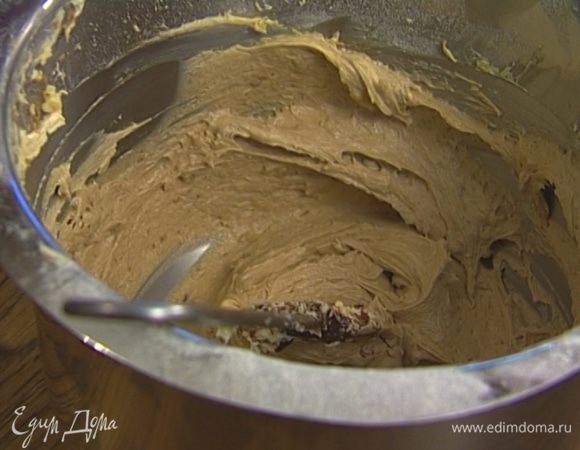 Всыпать просеянную муку и разрыхлитель, добавить оставшийся растворенный кофе и немного измельченных орехов, все вымешать.