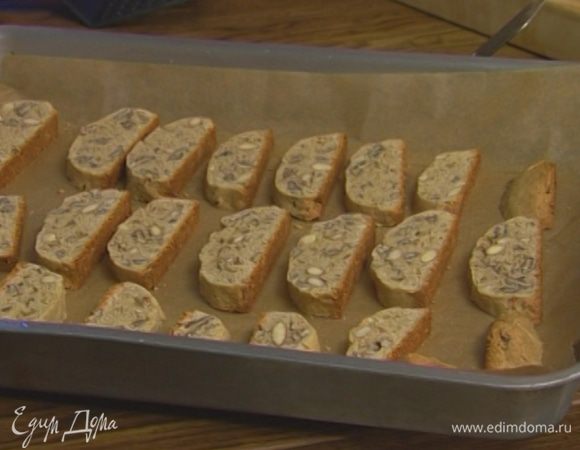 Увеличить температуру духовки до 180°С. Застелить противень бумагой для выпечки, уложить на него нарезанное печенье и выпекать еще 5—7 минут до золотистого цвета.