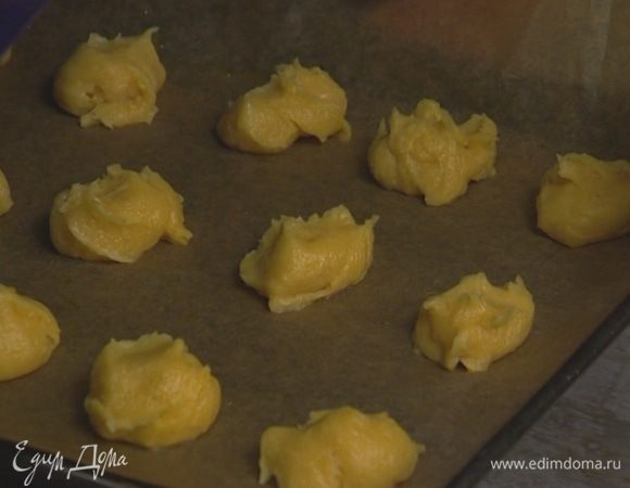 Застелить противень бумагой для выпечки, смазав ее оставшимся сливочным маслом. Ложкой выложить тесто в форме шариков на противень на расстоянии 2–3 см друг от друга.