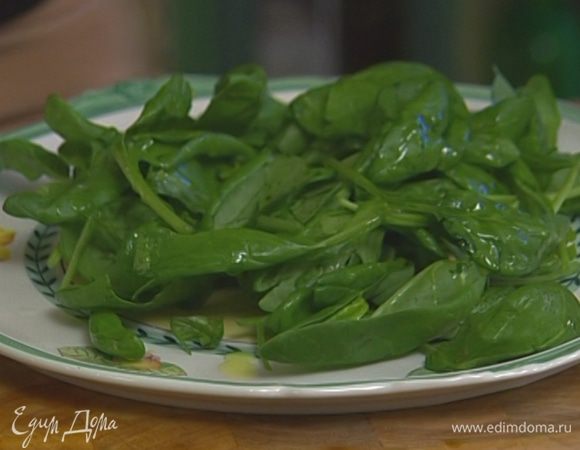 Шпинат вымыть, просушить, выложить на большое блюдо, сбрызнуть оливковым маслом и соком лимона, посолить и поперчить.