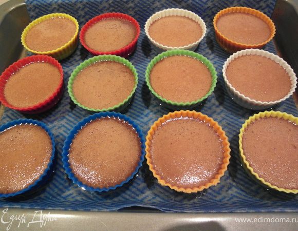 Осторожно достаем противень из духовки. Консистенция после выпекания остается еще весьма жидкой. Оставляем горшочки на противине в воде еще 30 - 40 минут.