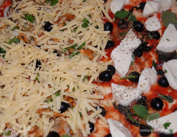 Части пиццы с лисичками и мидиями посыпаем натёртым на крупной тёрке сыром. Убираем в разогретую духовку и ждем до готовности. 