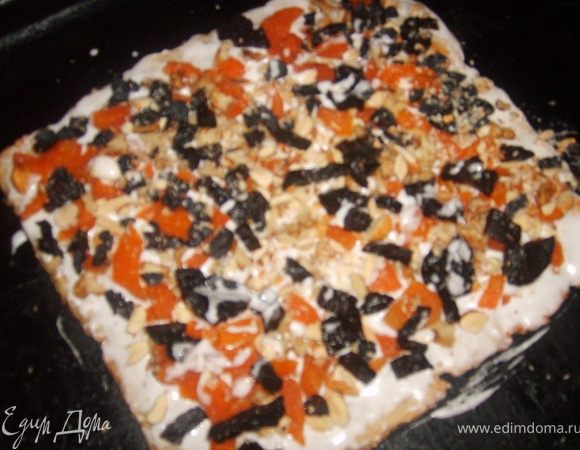 После разложить на корже начинку их орехов и сухофруктов